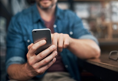 Closeup shot of an unrecognizable designer using a cellphone in an office